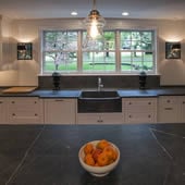 kitchen remodel with farmhouse sink, black countertops, and white countertops 